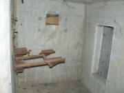 Částečně zachovalý střelecký stolek, zaslepená boční střílna a vchod do místnosti
